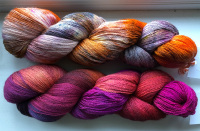Two glorious yarns Two skeins, one orange/pale lilac/yellow/grey, one shades of red and purple